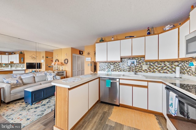500 32nd St Unit A, Ocean City, MD 21842 - kitchen with stainless steel appliances, a sink, a peninsula, light wood finished floors, and light countertops