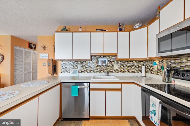 500 32nd St Unit A, Ocean City, MD 21842 - kitchen featuring stainless steel appliances, a sink, white cabinets, and a textured ceiling