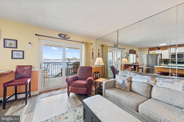 500 32nd St Unit A, Ocean City, MD 21842 - living area featuring a textured ceiling, light wood-style floors, and baseboards