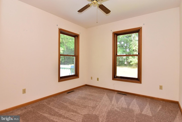 carpeted spare room with ceiling fan