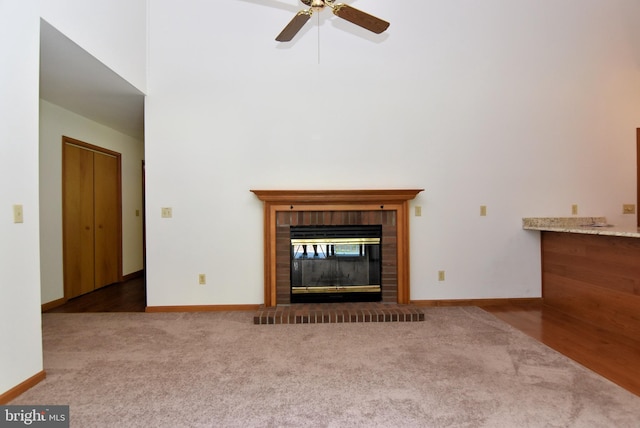 unfurnished living room featuring ceiling fan, a fireplace, and wood-type flooring