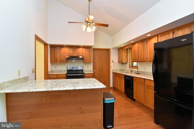 kitchen featuring ceiling fan, high vaulted ceiling, light stone counters, and black appliances