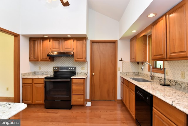 kitchen with light wood-type flooring, backsplash, sink, and black appliances