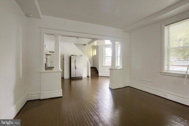 interior space with decorative columns and dark hardwood / wood-style floors