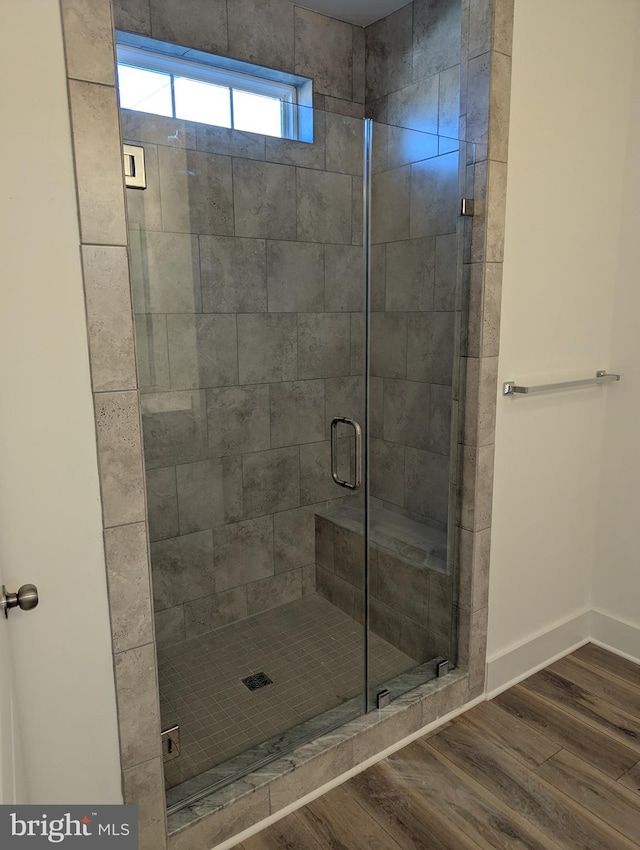 bathroom with an enclosed shower and wood-type flooring