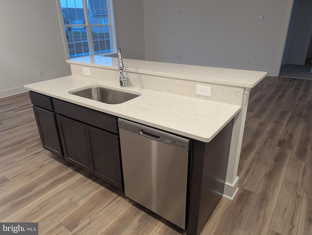 kitchen featuring hardwood / wood-style flooring, dishwasher, a center island with sink, and sink