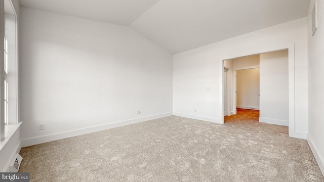 empty room featuring light carpet and lofted ceiling