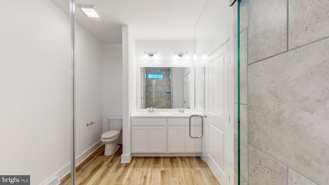 bathroom with vanity, toilet, wood-type flooring, and a shower with shower door