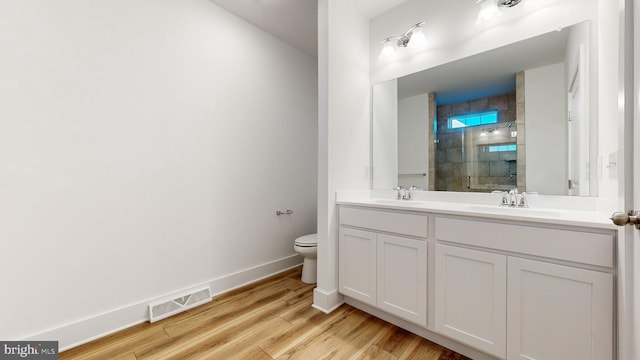 bathroom featuring vanity, toilet, a shower with shower door, and wood-type flooring