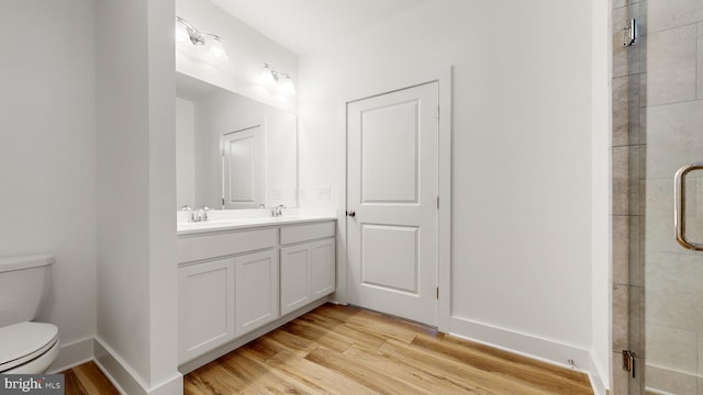 bathroom featuring vanity, hardwood / wood-style flooring, toilet, and walk in shower