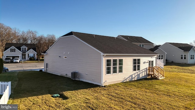 back of property featuring cooling unit and a lawn