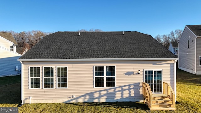 rear view of property featuring a lawn