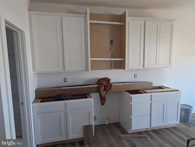 kitchen with hardwood / wood-style floors and white cabinets