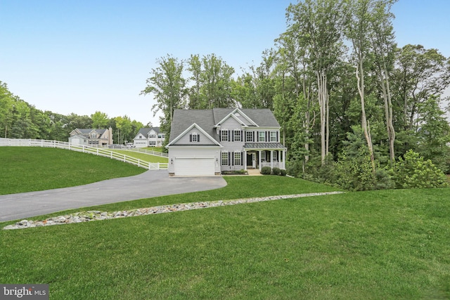 view of front facade with a porch, a front yard, and a garage