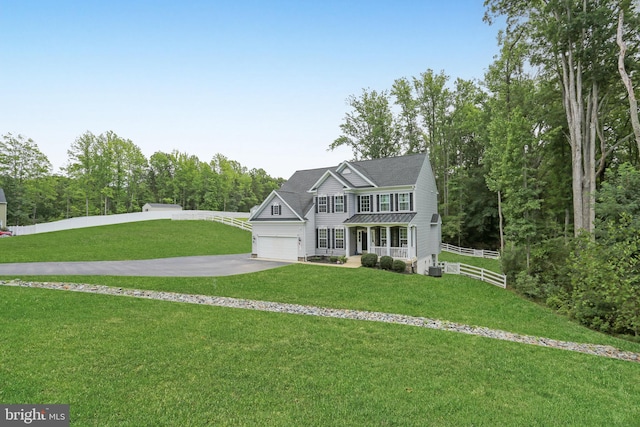 view of front of house with a front yard, a garage, and covered porch