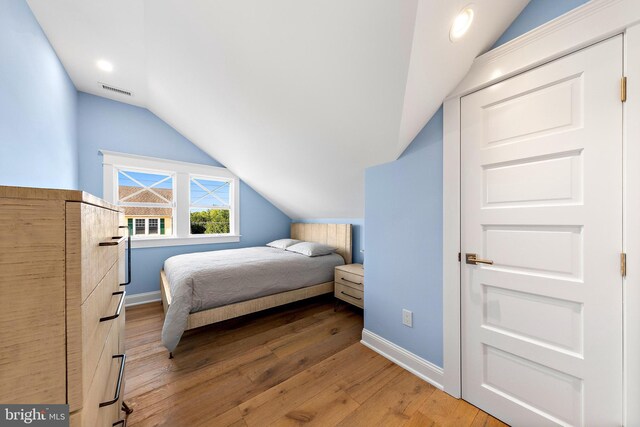 bedroom featuring vaulted ceiling and hardwood / wood-style flooring