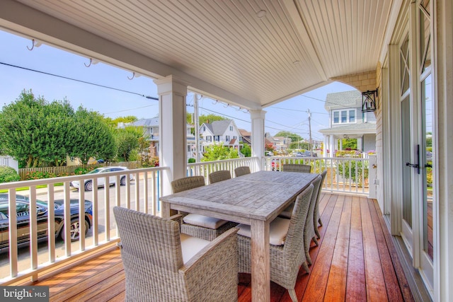 wooden terrace with outdoor dining space and a residential view