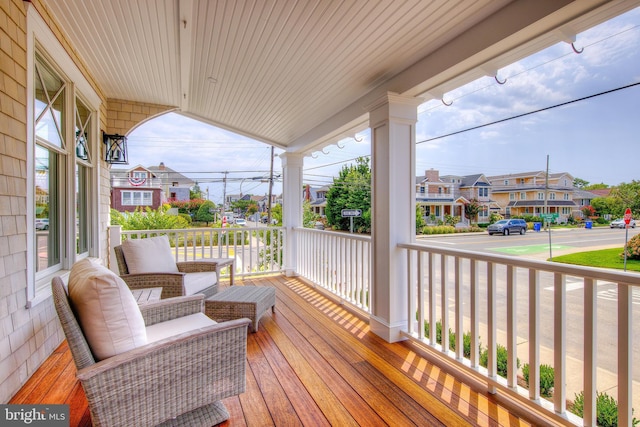 deck featuring covered porch and a residential view