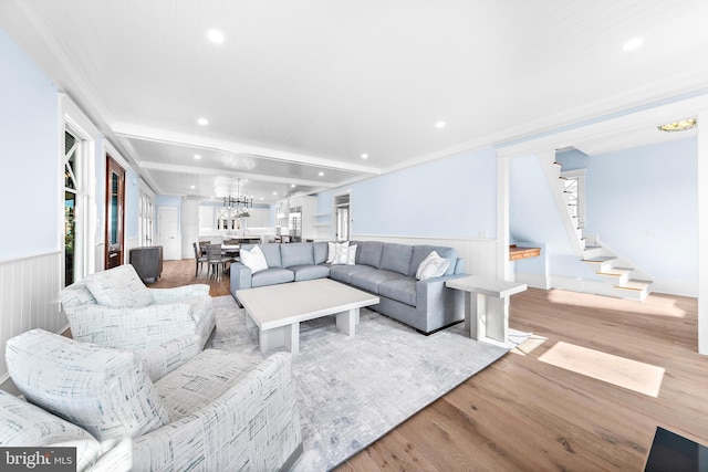 living area with recessed lighting, a wainscoted wall, stairs, beam ceiling, and light wood finished floors