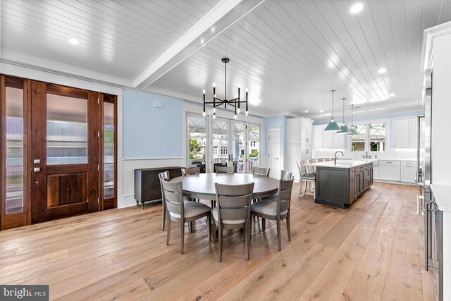 dining area with beam ceiling, light hardwood / wood-style floors, french doors, sink, and a notable chandelier