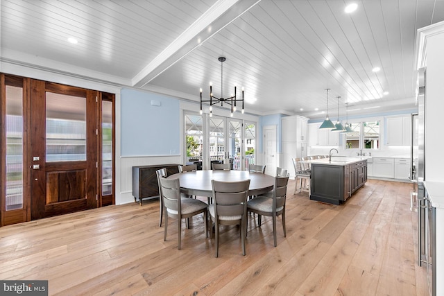 dining area featuring a notable chandelier, light wood finished floors, wood ceiling, and crown molding