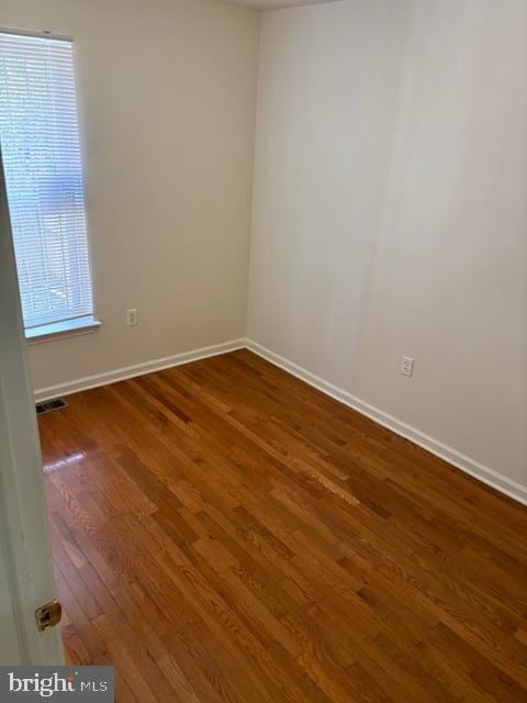 unfurnished room with dark wood-type flooring