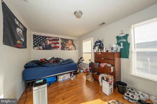 bedroom with hardwood / wood-style flooring and multiple windows