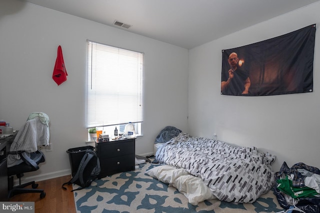 bedroom featuring multiple windows and hardwood / wood-style flooring