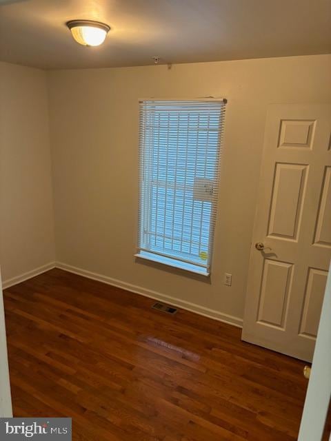 unfurnished room with dark hardwood / wood-style flooring