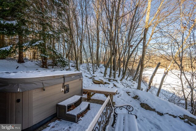 yard layered in snow with a hot tub