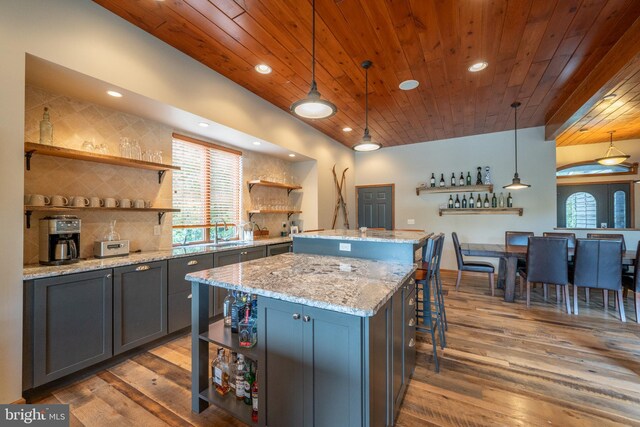 kitchen with a kitchen island, wood-type flooring, and decorative light fixtures