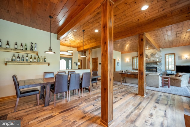 dining space with a fireplace, hardwood / wood-style flooring, and wooden ceiling