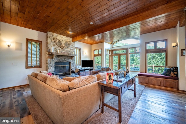 living room featuring beamed ceiling, wood-type flooring, a fireplace, and wood ceiling