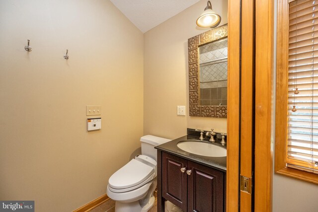 bathroom featuring a textured ceiling, vanity, and toilet