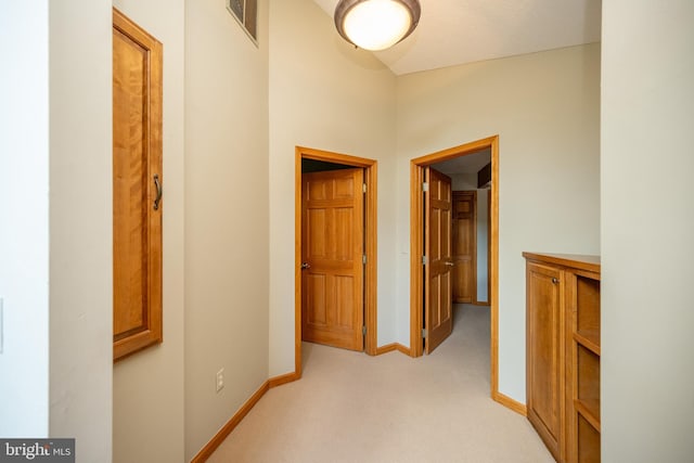 hall with light colored carpet