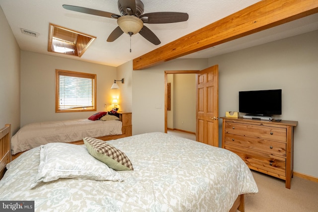 carpeted bedroom featuring beamed ceiling and ceiling fan