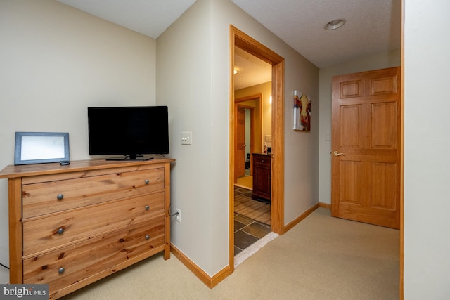 bedroom with light carpet and connected bathroom