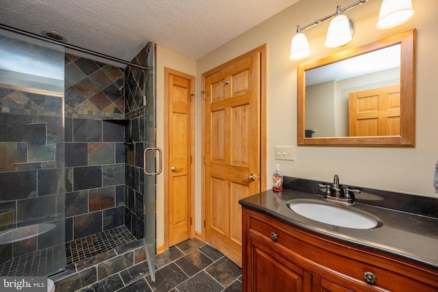 bathroom featuring a textured ceiling, vanity, and an enclosed shower