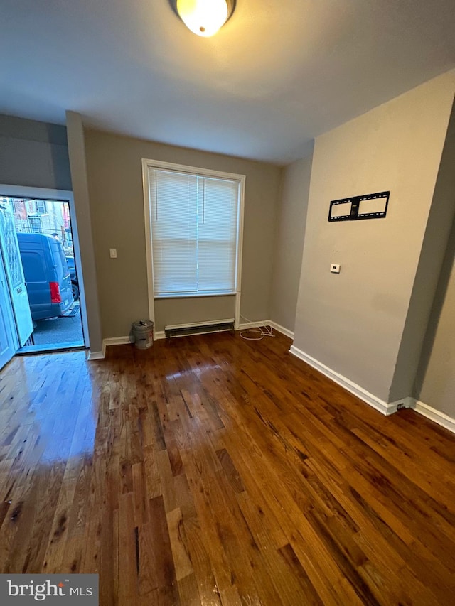 interior space with a baseboard radiator and dark wood-type flooring