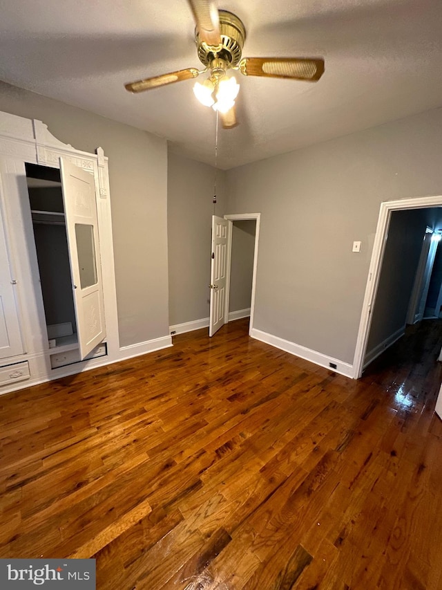 unfurnished bedroom featuring dark wood-type flooring and ceiling fan