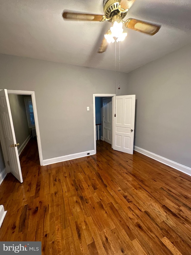 unfurnished bedroom with ceiling fan and dark hardwood / wood-style floors