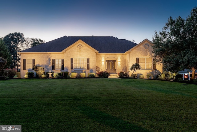 view of front of home with brick siding and a front yard