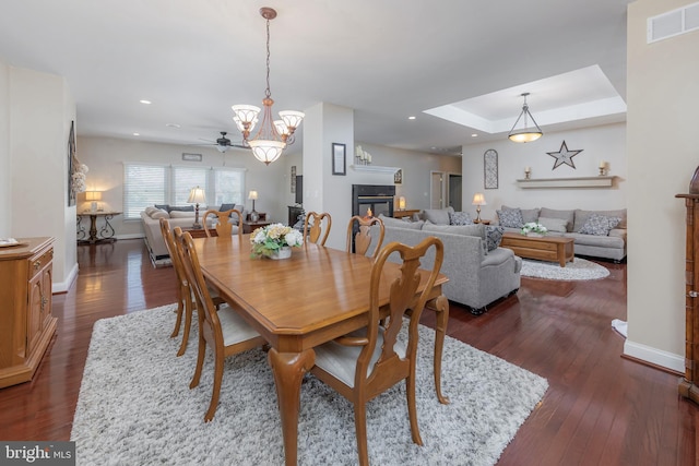 dining room with baseboards, visible vents, recessed lighting, dark wood-style flooring, and a glass covered fireplace