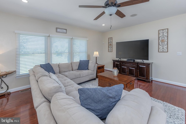 living room featuring dark wood-type flooring, recessed lighting, and baseboards