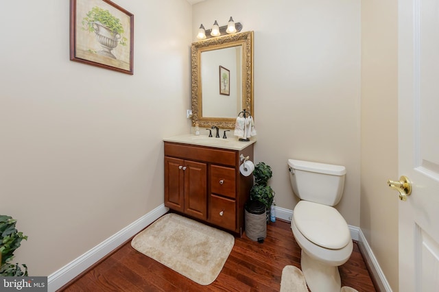 bathroom featuring toilet, wood finished floors, and baseboards