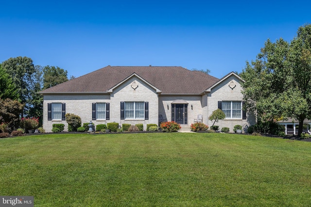 ranch-style house with brick siding, roof with shingles, and a front yard