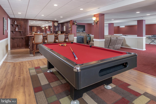 playroom with recessed lighting, a bar, baseboards, and wood finished floors