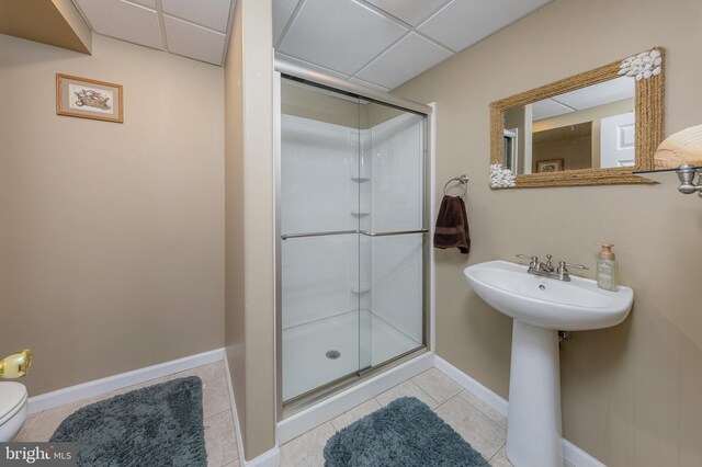 full bath featuring tile patterned floors, a drop ceiling, and a stall shower