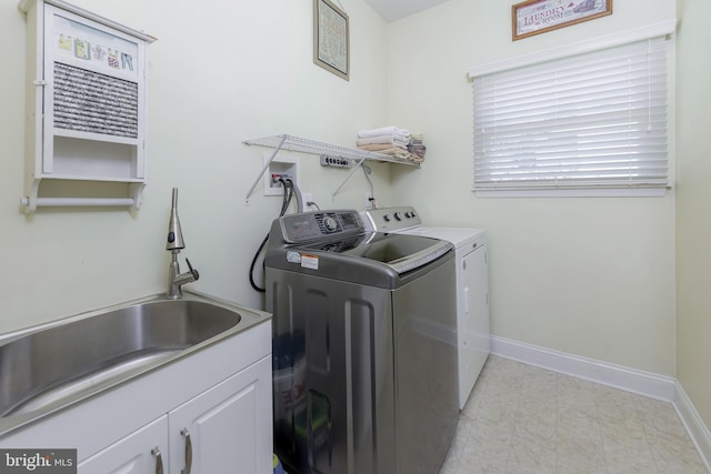 laundry area with a sink, baseboards, cabinet space, and washer and clothes dryer