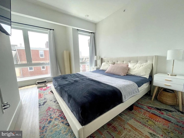 bedroom with lofted ceiling and hardwood / wood-style floors